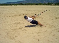 Stand and slide on the beach using power from the kite 